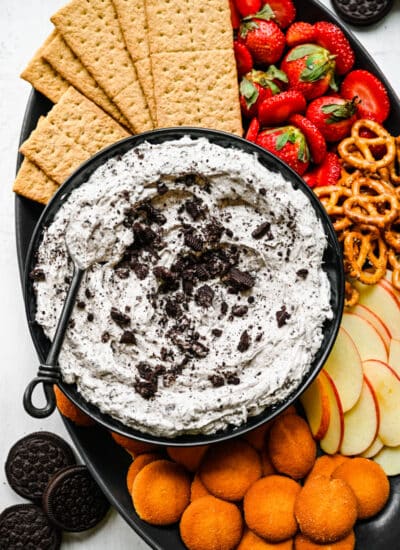 Oreo fluff in a black bowl with a spoon in it.