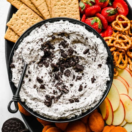 Oreo fluff in a black bowl with a spoon in it.