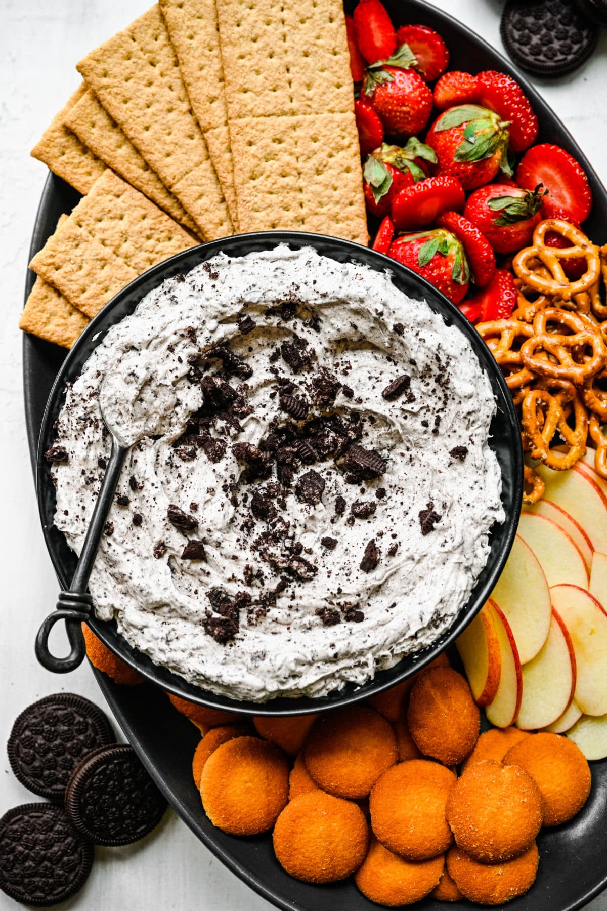 Oreo fluff in a black bowl with a spoon in it.