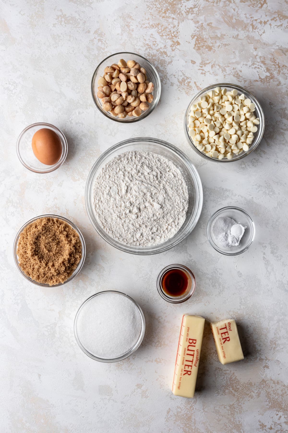 Ingredients in dishes for white chocolate macadamia nut cookies. 
