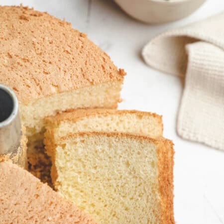 Two slices of chiffon cake next to the entire cake.