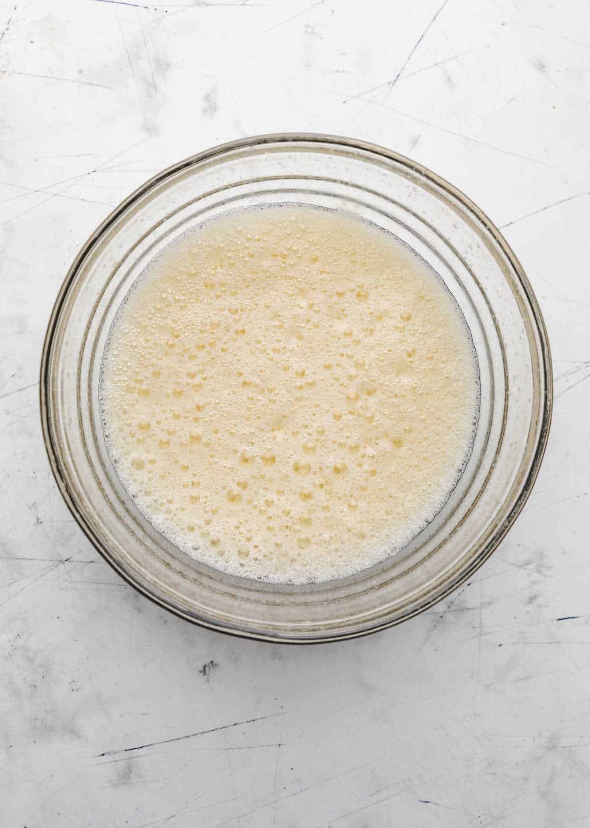 Egg yolk mixture in a glass mixing bowl. 