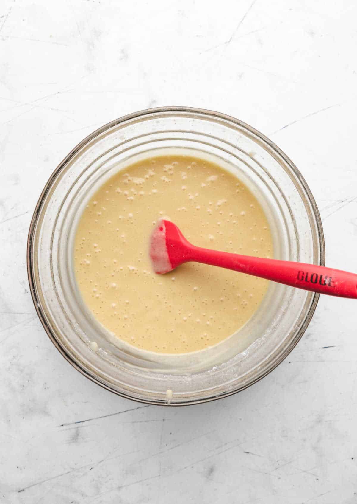 Egg yolk and flour mixture in a glass mixing bowl. 