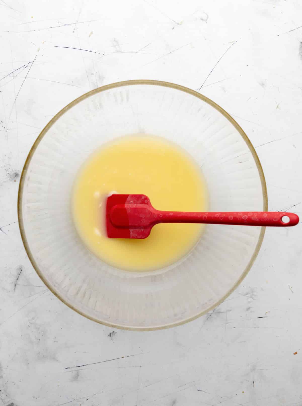 Melted butter with a red spatula in it.