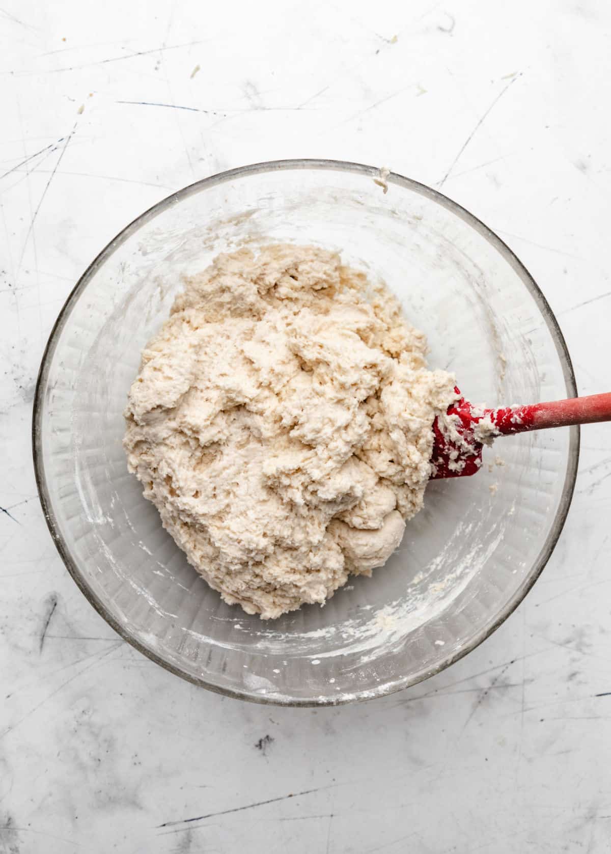 Buttermilk biscuit dough in a glass mixing bowl. 