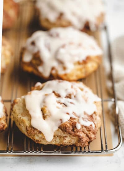 Iced cinnamon swirl biscuits on a wire cooling rack.