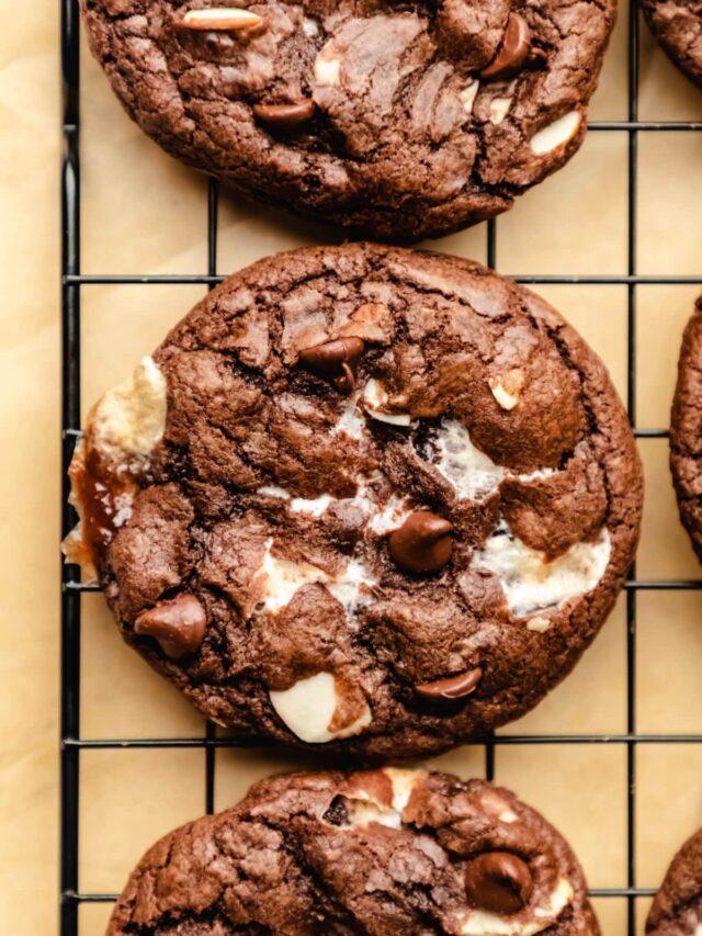 A rocky road cookie on a black cooling rack.
