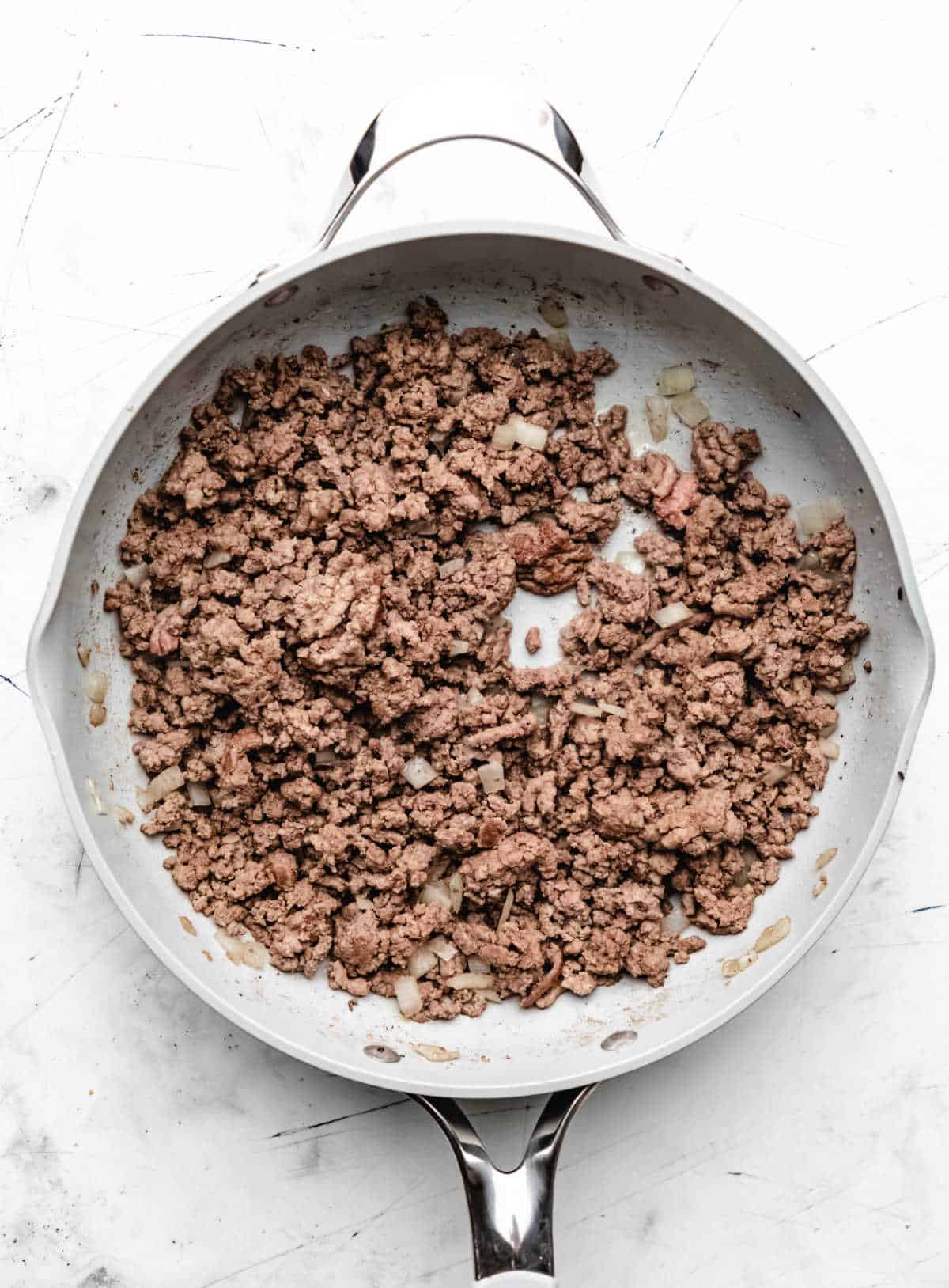 Browned ground beef and onions in a large skillet. 