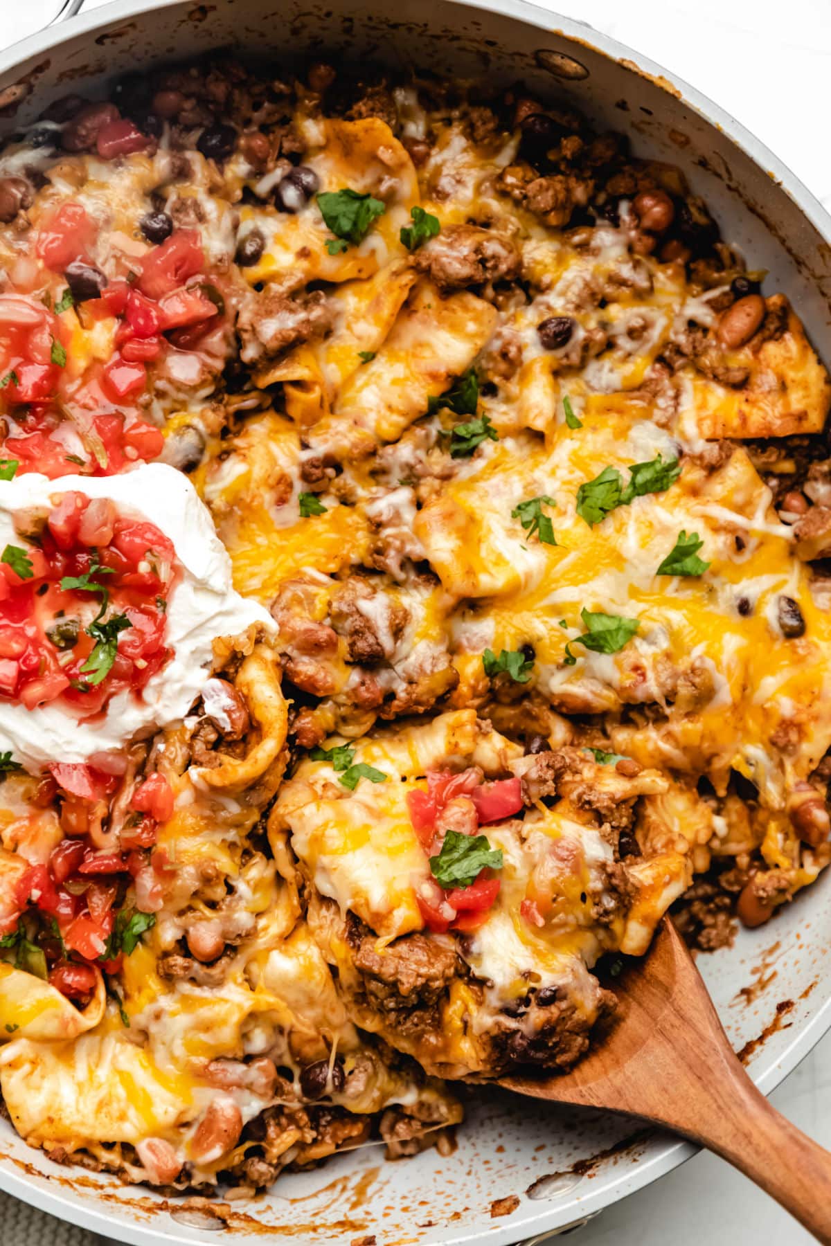 Ground beef burrito skillet topped with sour cream and pico de gallo. 