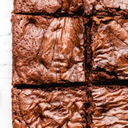 Mexican chocolate brownies cut into squares on a piece of parchment paper.