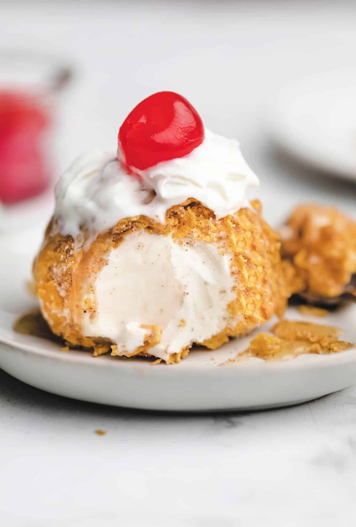 No fry fried ice cream topped with whipped cream and a cherry.