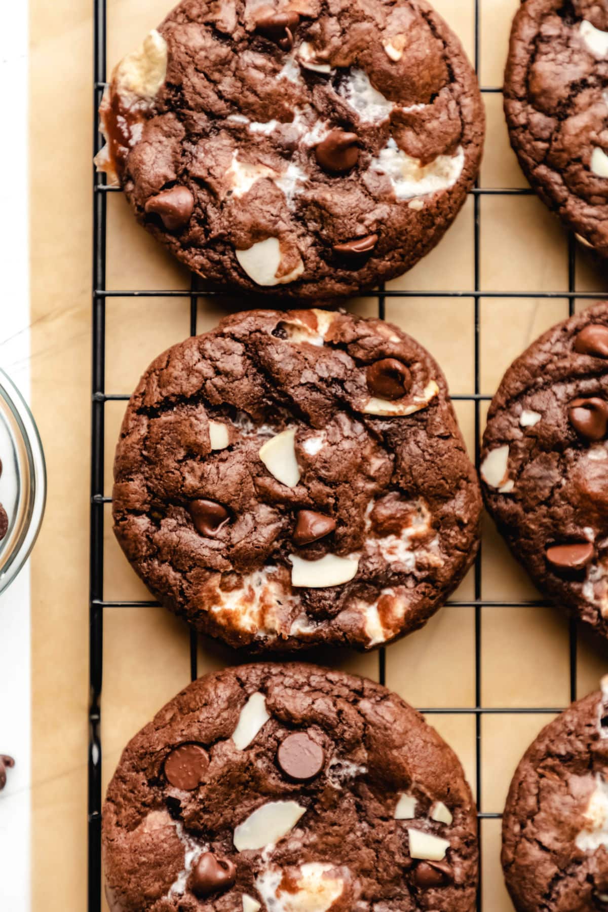 Rocky road cookies on a wire rack above a piece of brown parchment paper. 