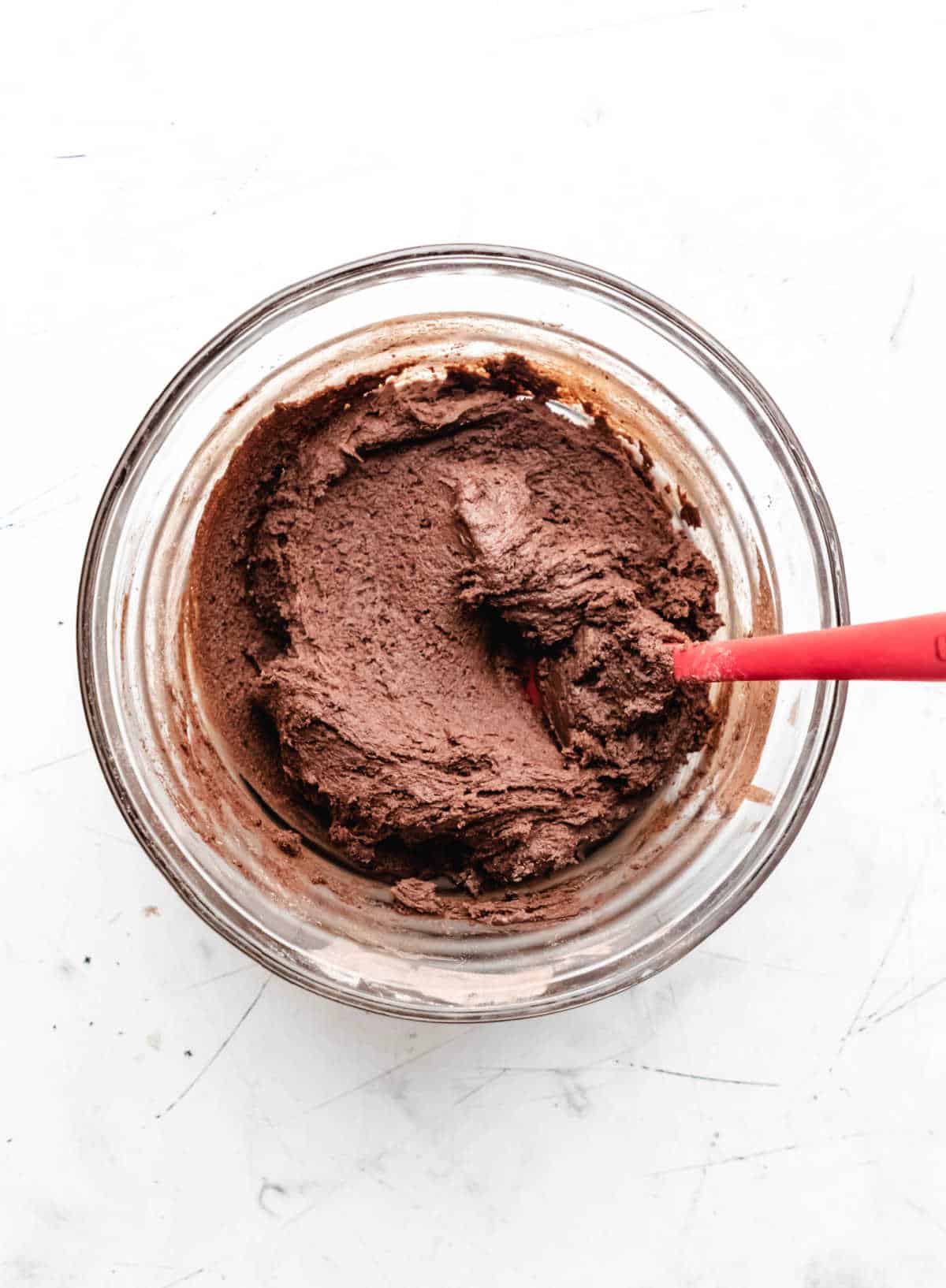 Chocolate cookie dough in a glass mixing bowl. 