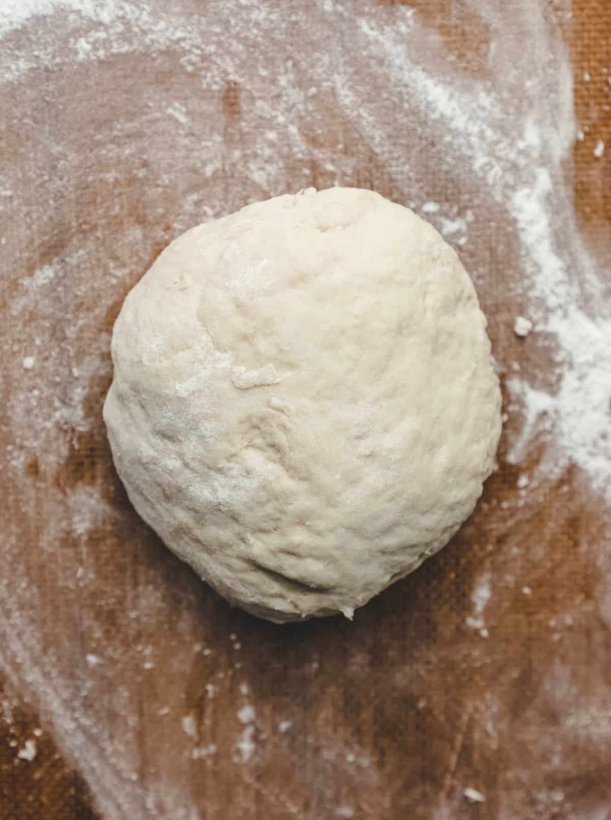 Sopaipilla dough in a ball on a silicone baking mat. 