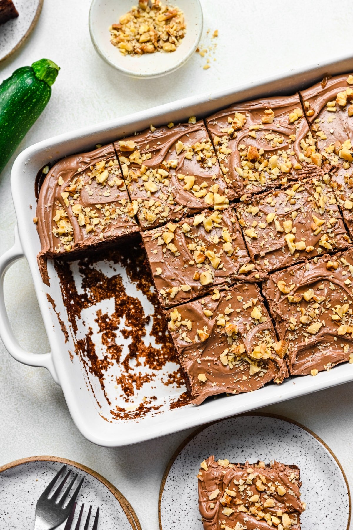 Two pieces of chocolate zucchini cake cut from a pan of cake. 