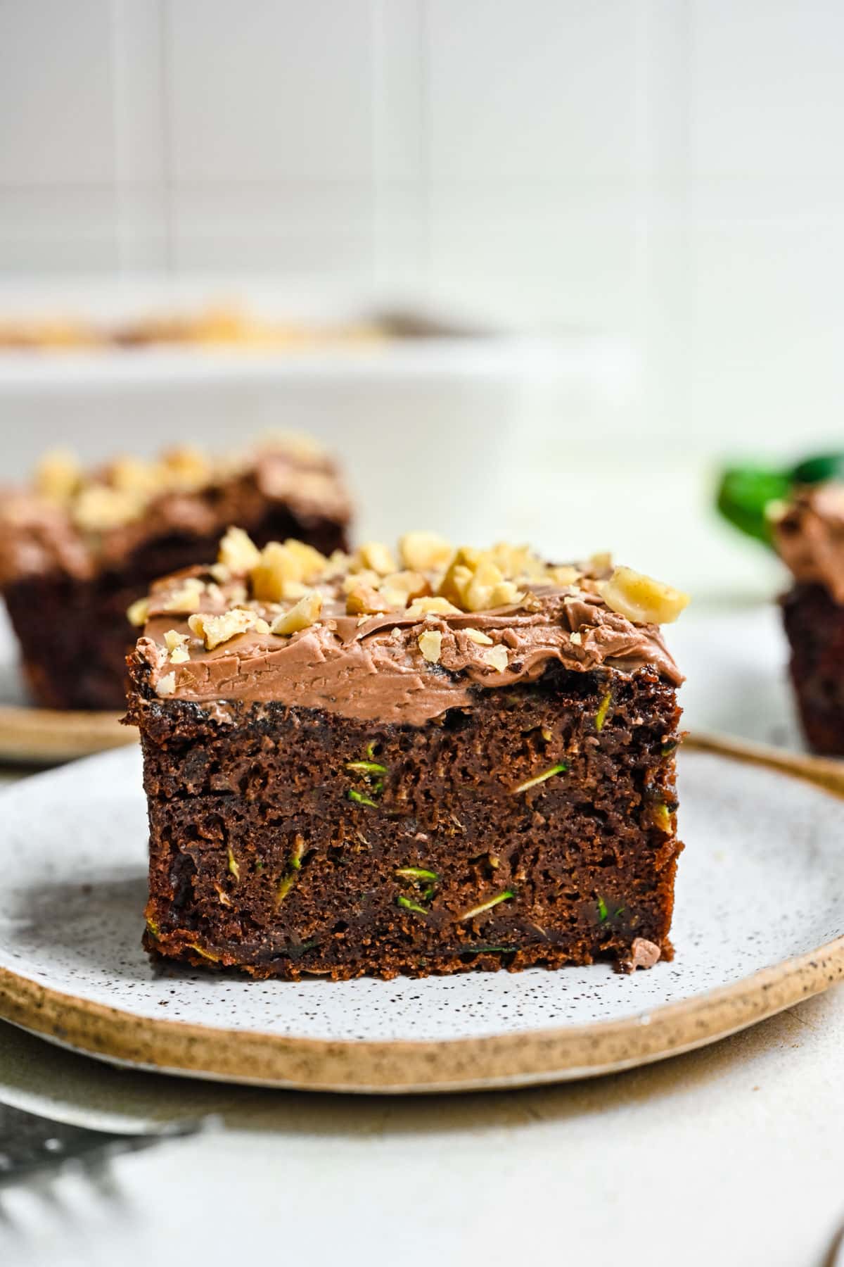 Pieces of chocolate zucchini cake on plates. 