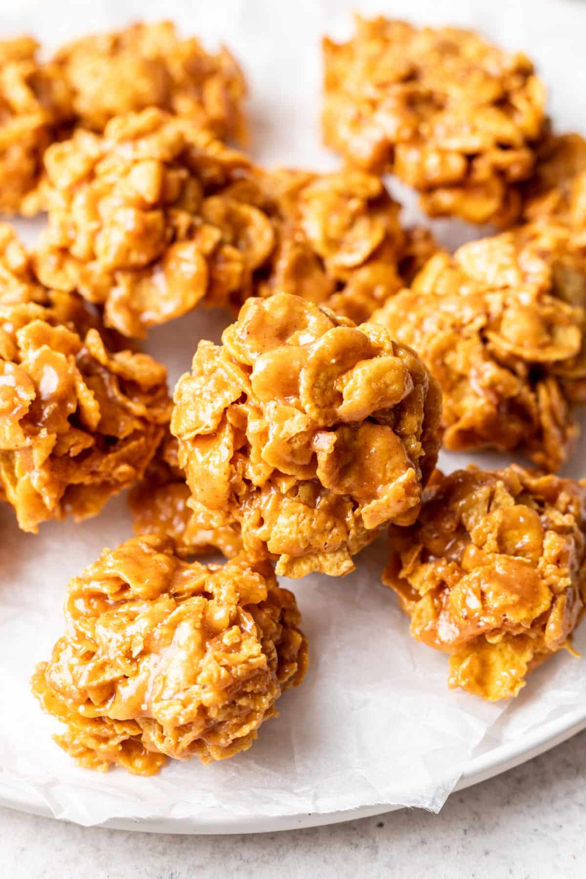 A white plate with several peanut butter cornflake cookies on it.