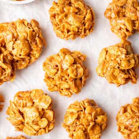 Rows of peanut butter cornflake cookies on parchment paper.