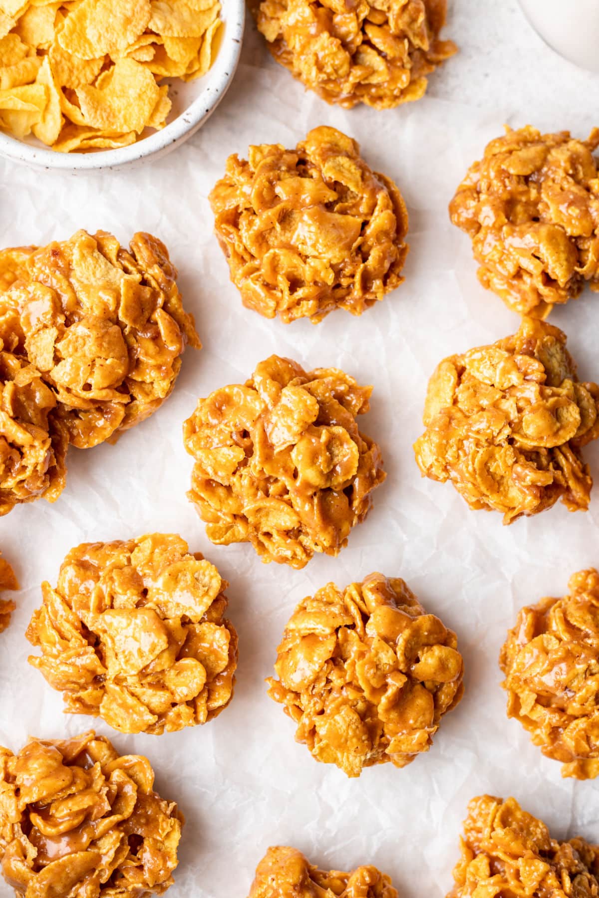 Rows of peanut butter cornflake cookies on parchment paper.