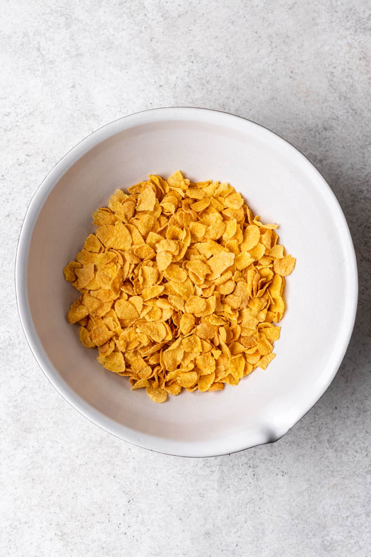 Cornflakes in a white mixing bowl. 