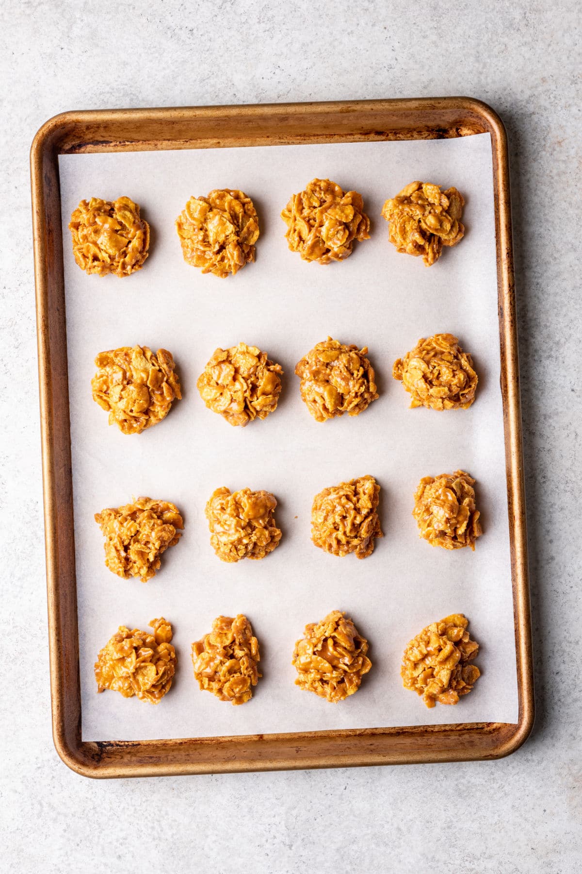Peanut butter cornflake cookies on a baking sheet.