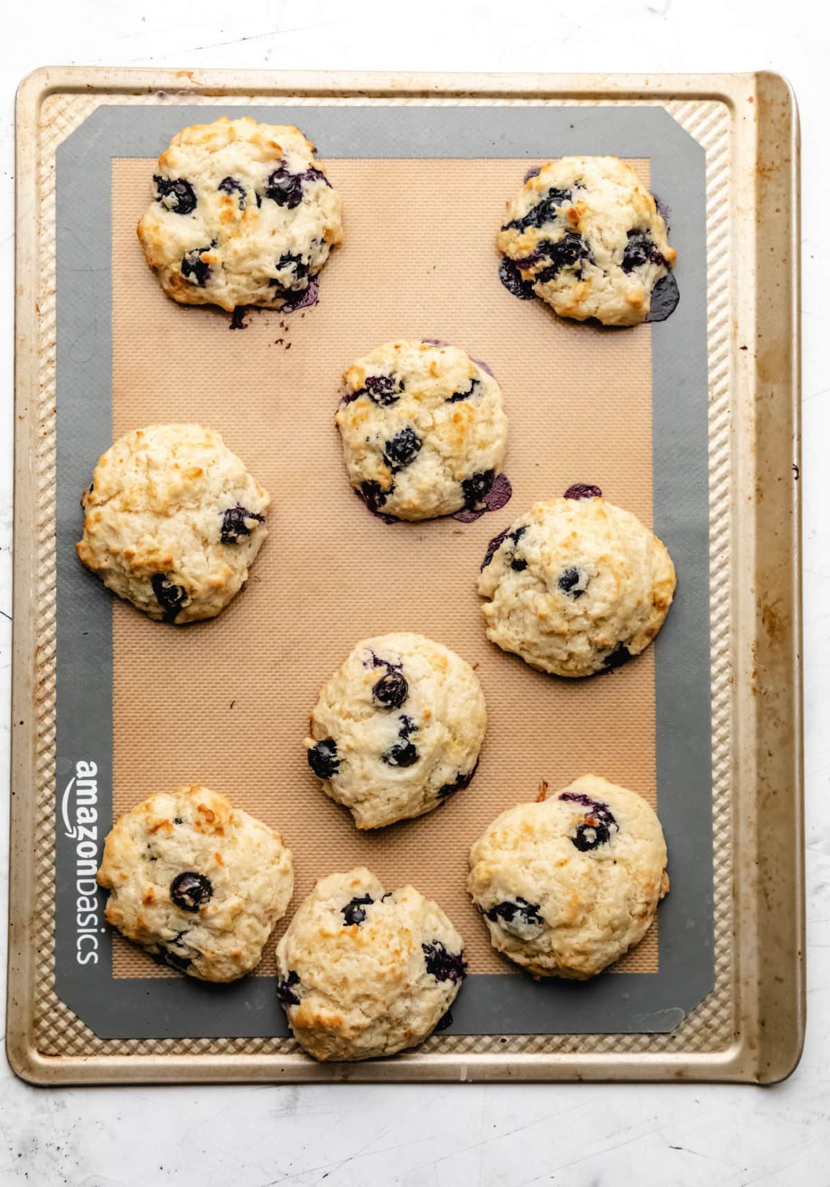 Baked blueberry biscuits on a baking sheet.