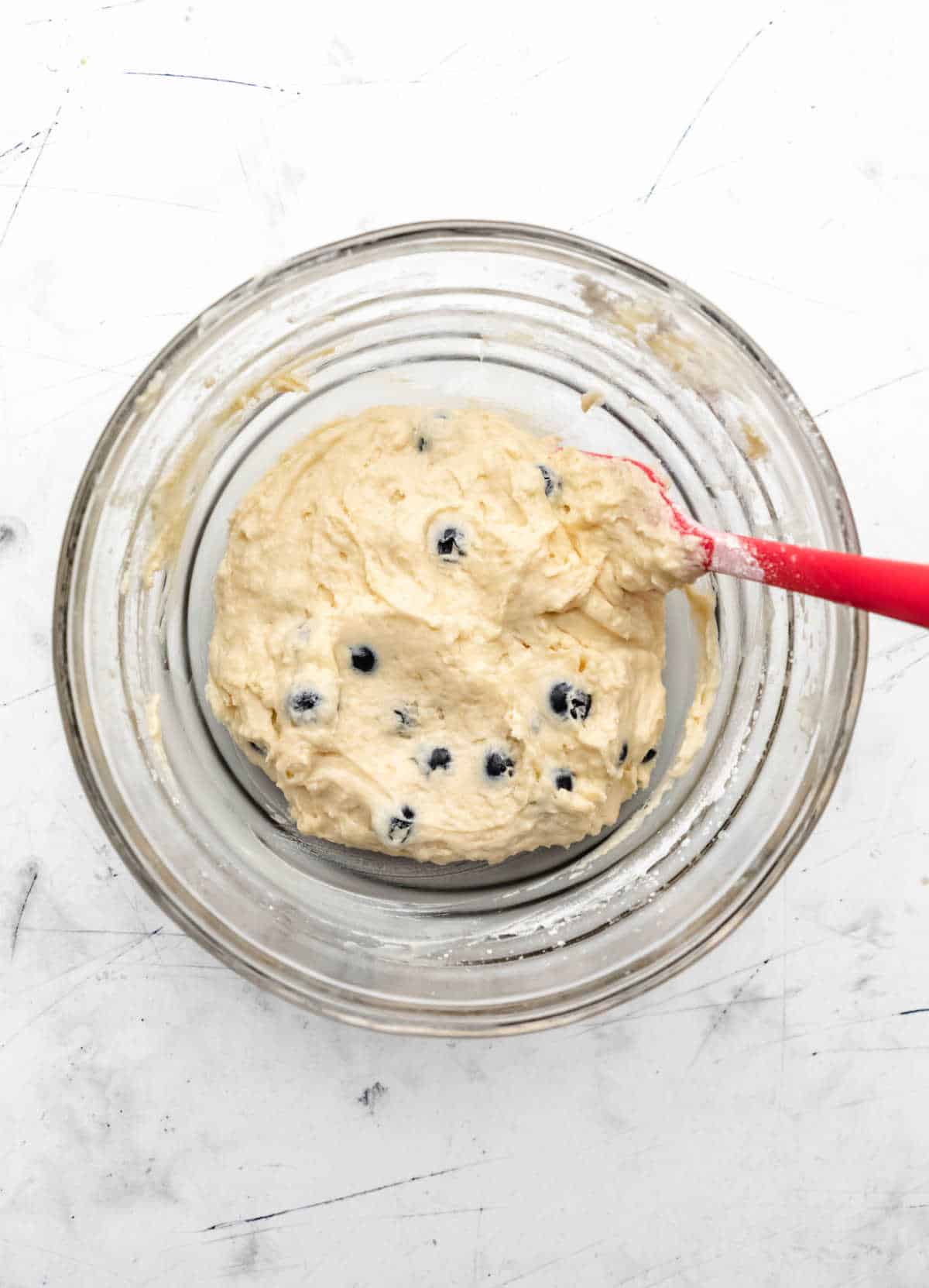 Blueberry cake batter in a glass mixing bowl. 