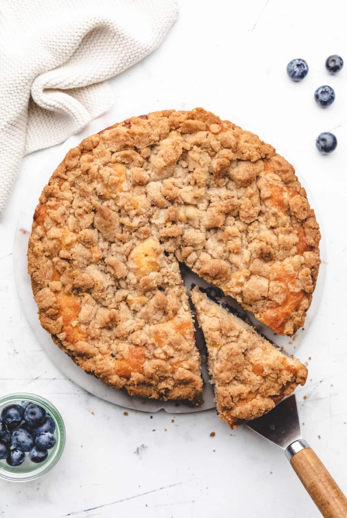 A slice of blueberry crumb cake cut from the cake. 