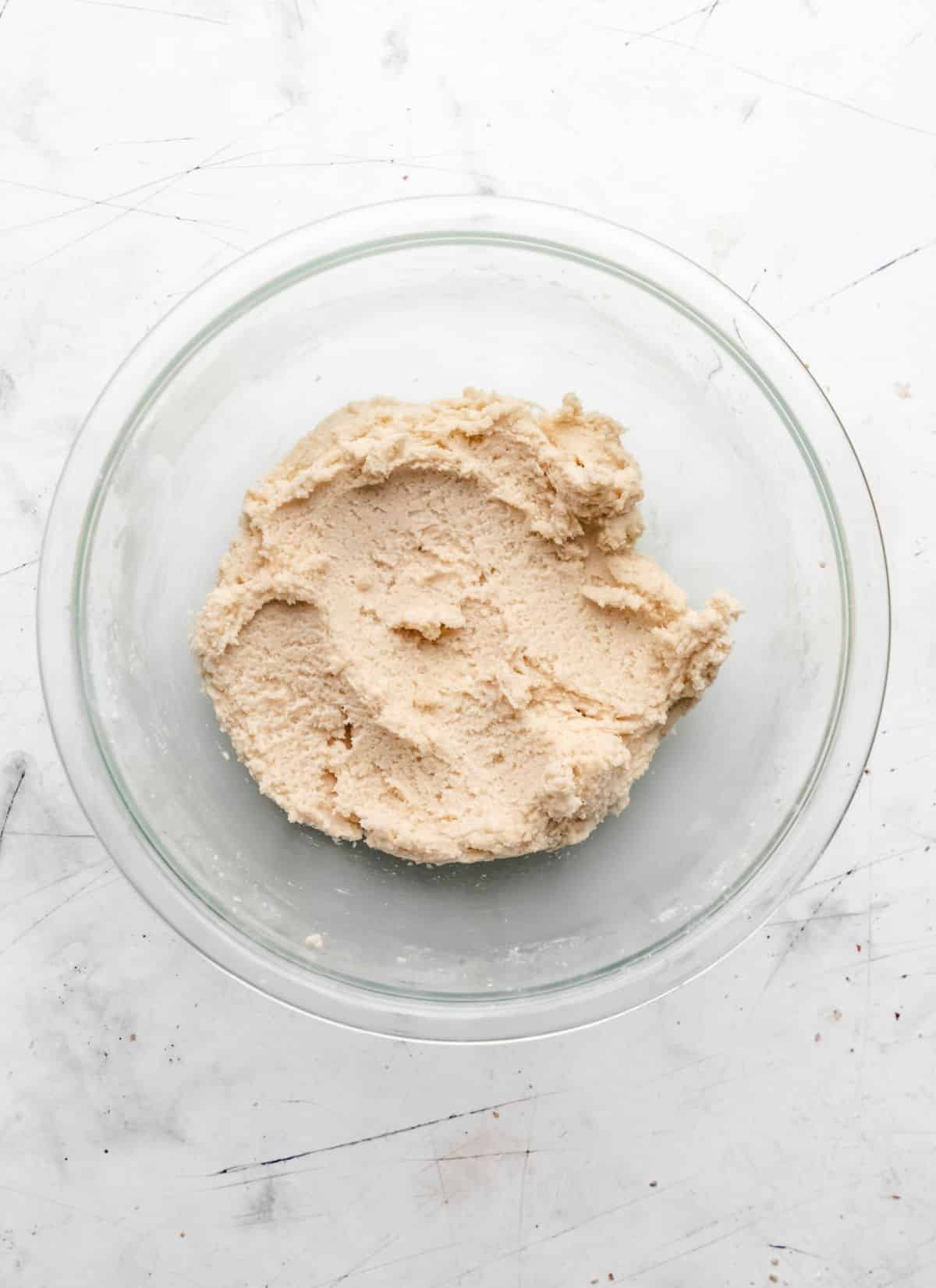 Cookie dough in a glass mixing bowl. 