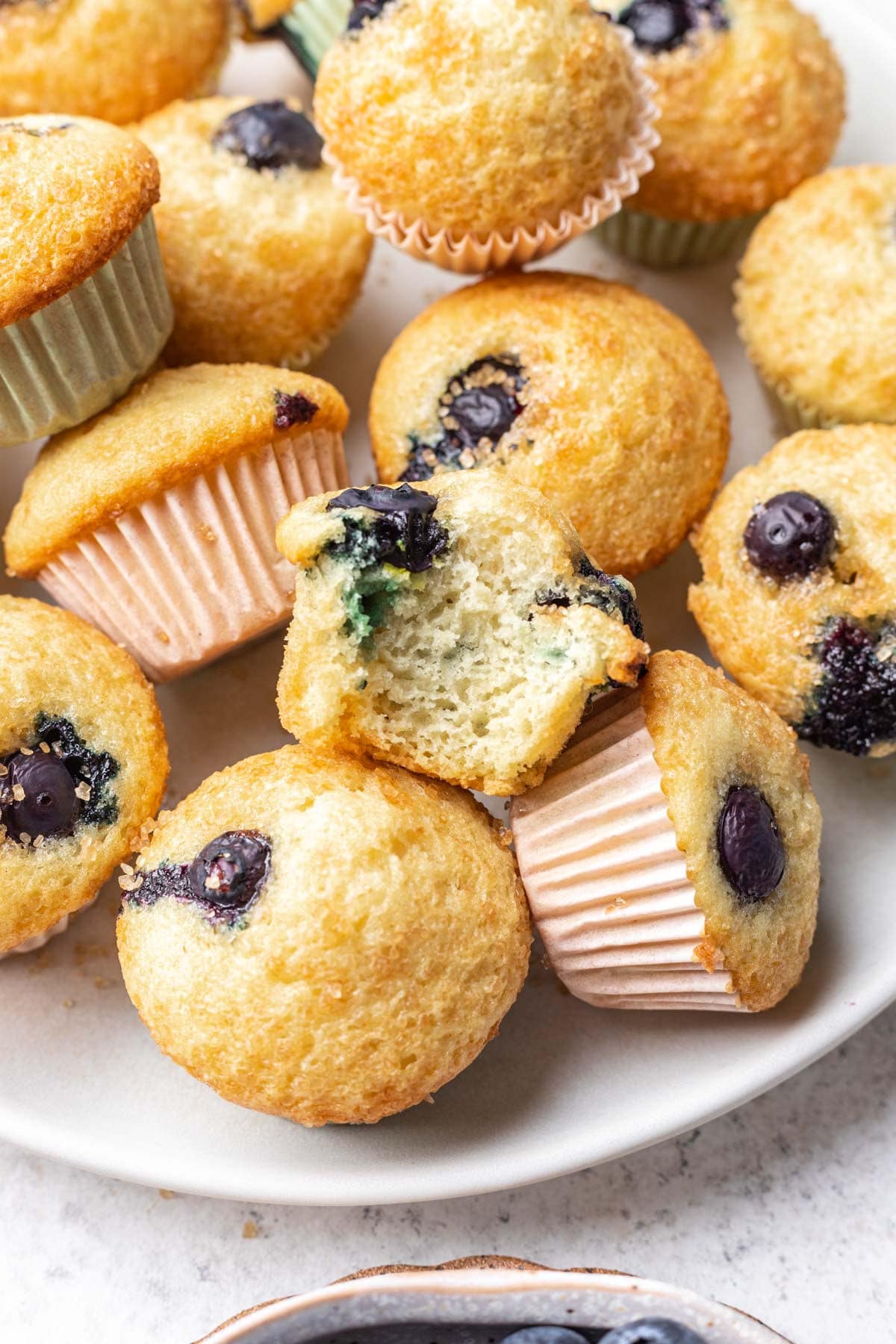 A plate of mini blueberry muffins stacked on each other. 