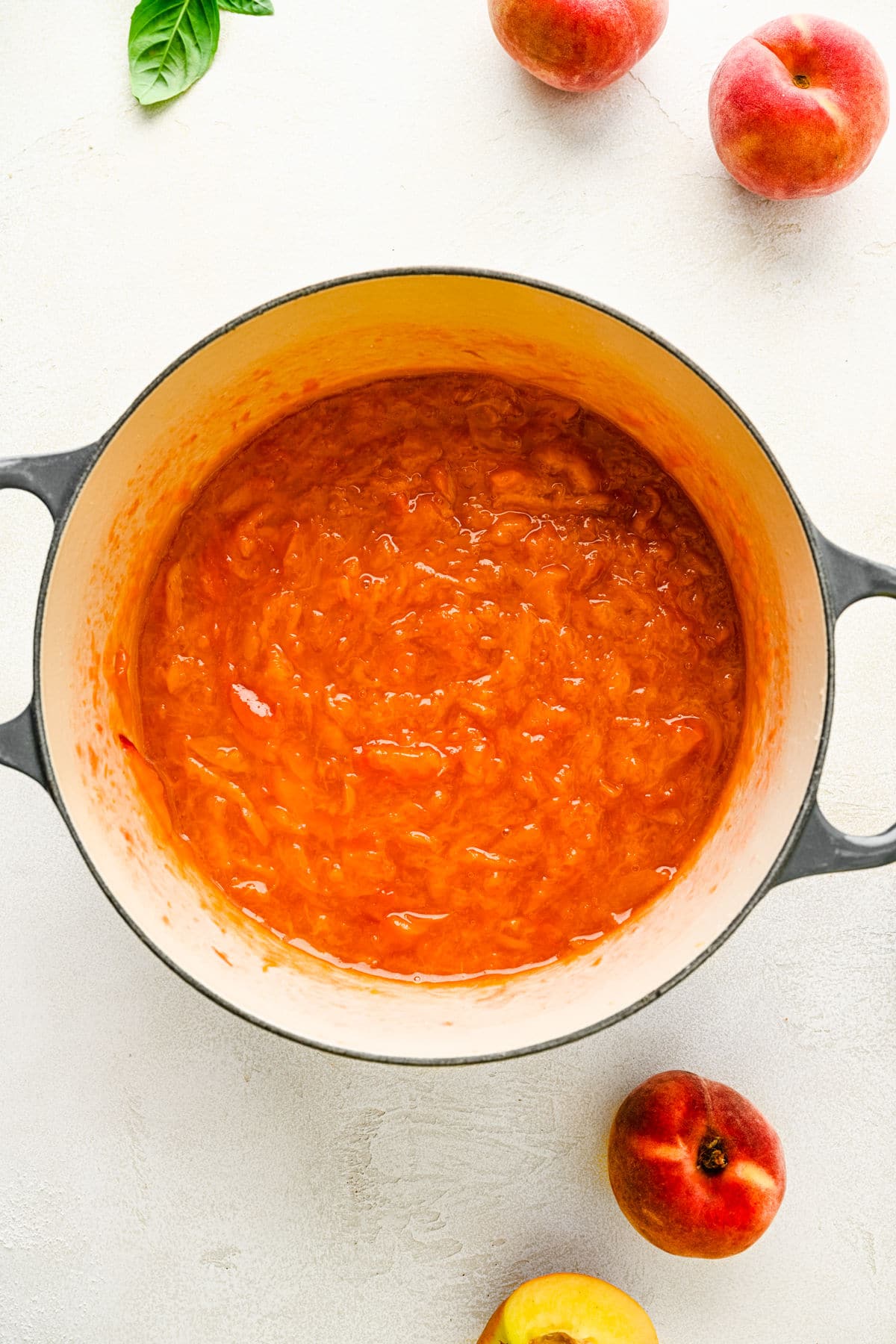 Cooked peach syrup in a Dutch oven.