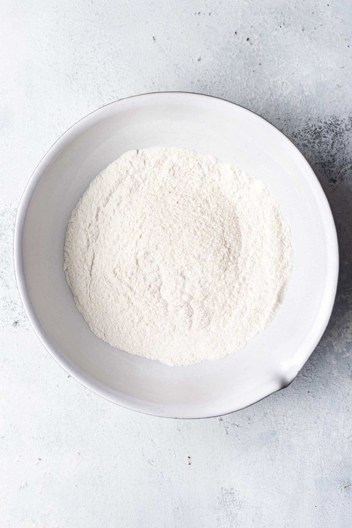 Dry ingredients for coconut muffins in a mixing bowl. 