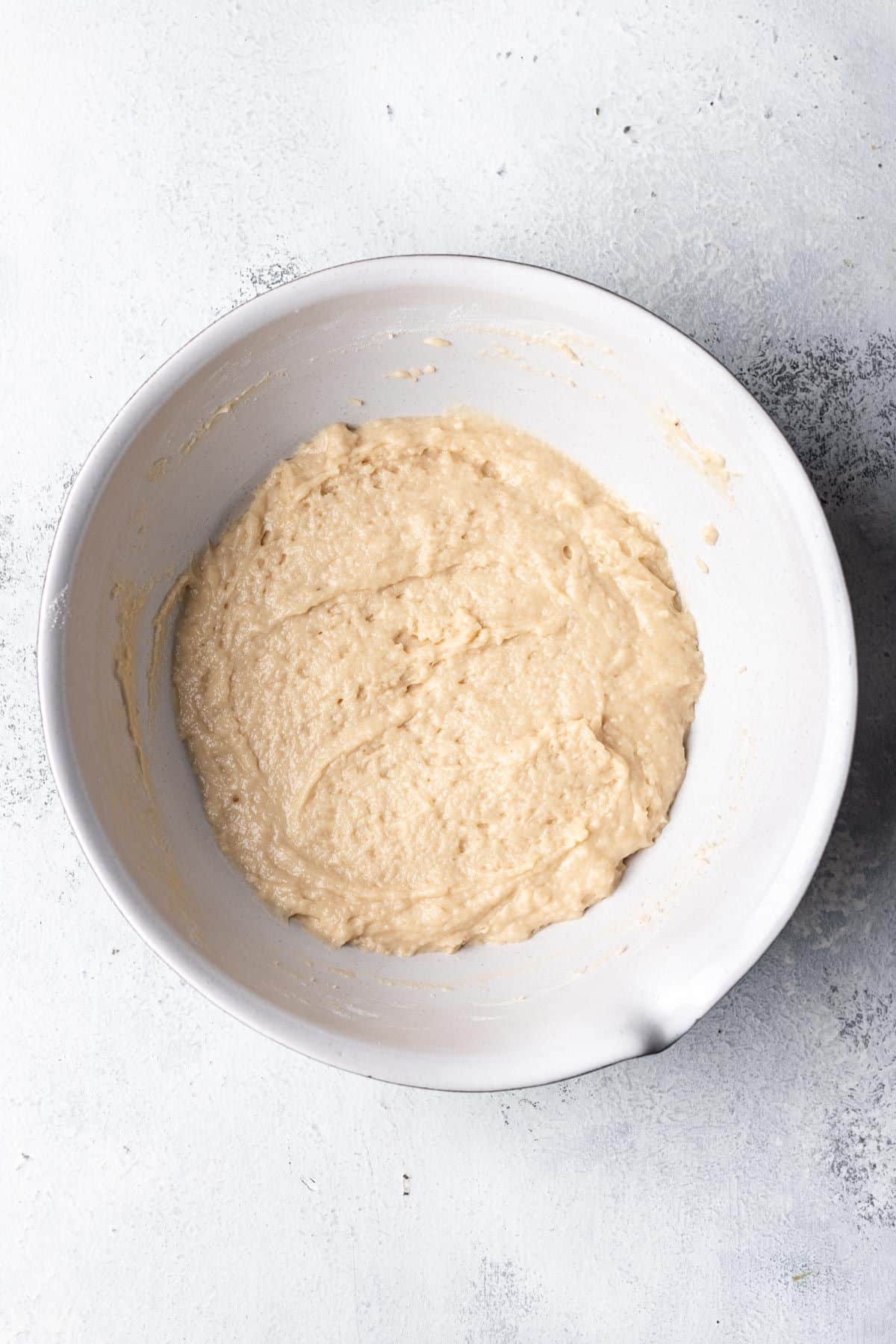 Coconut muffin batter in a mixing bowl. 