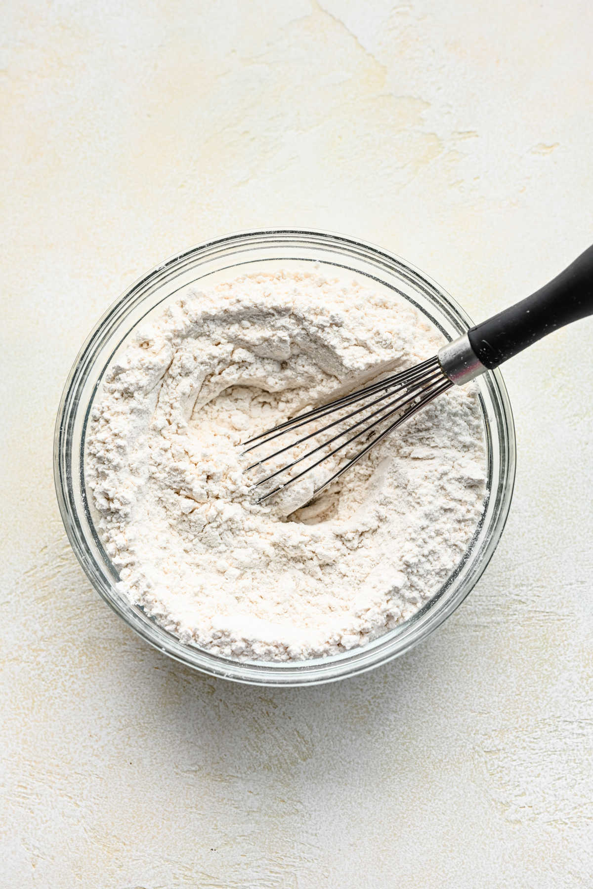Flour and salt whisked together in a glass mixing bowl. 