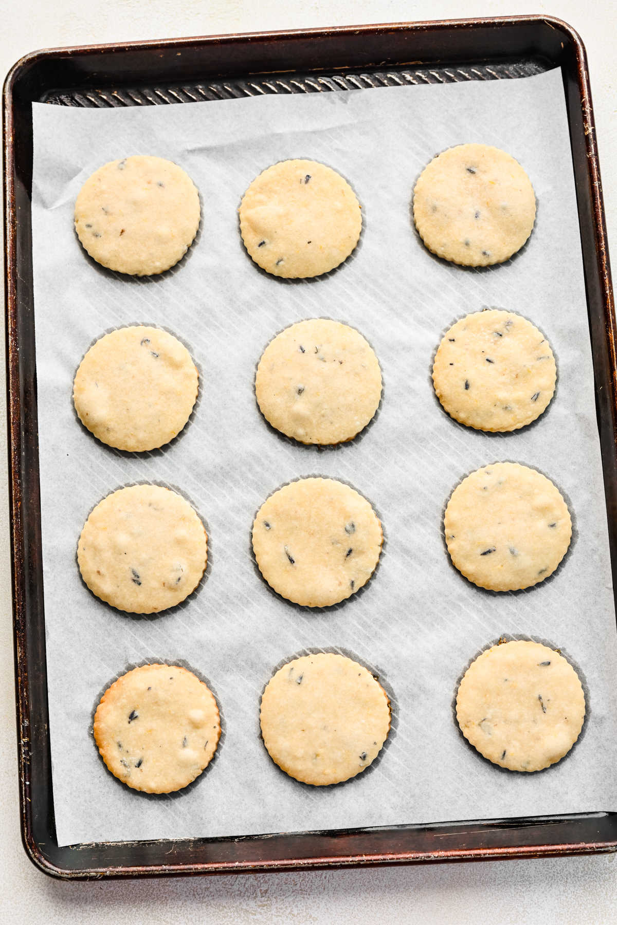 Baked lavender cookies on a parchment lined baking sheet.