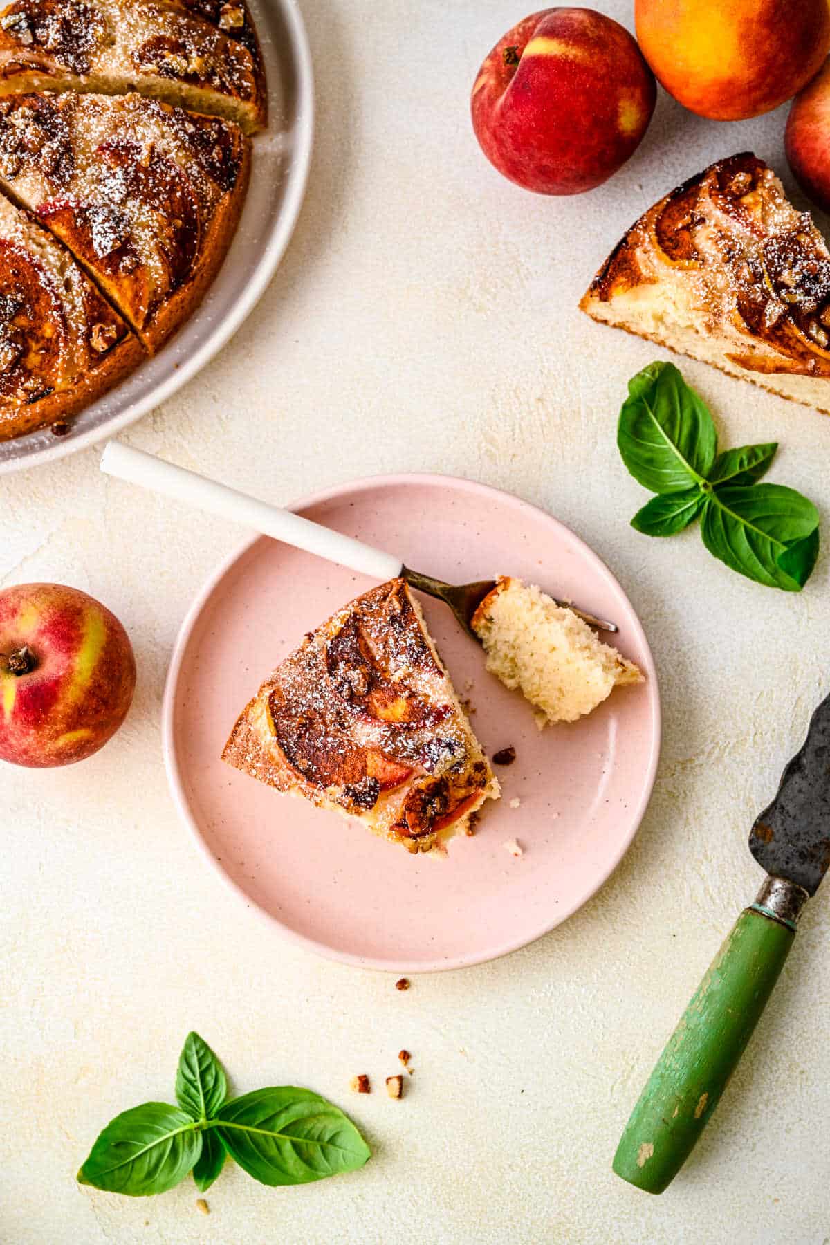 A slice of peach cake with a fork taking a bite. 