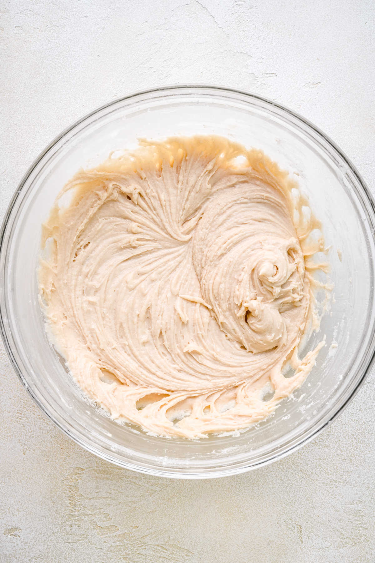 Peach cake batter in a glass mixing bowl. 