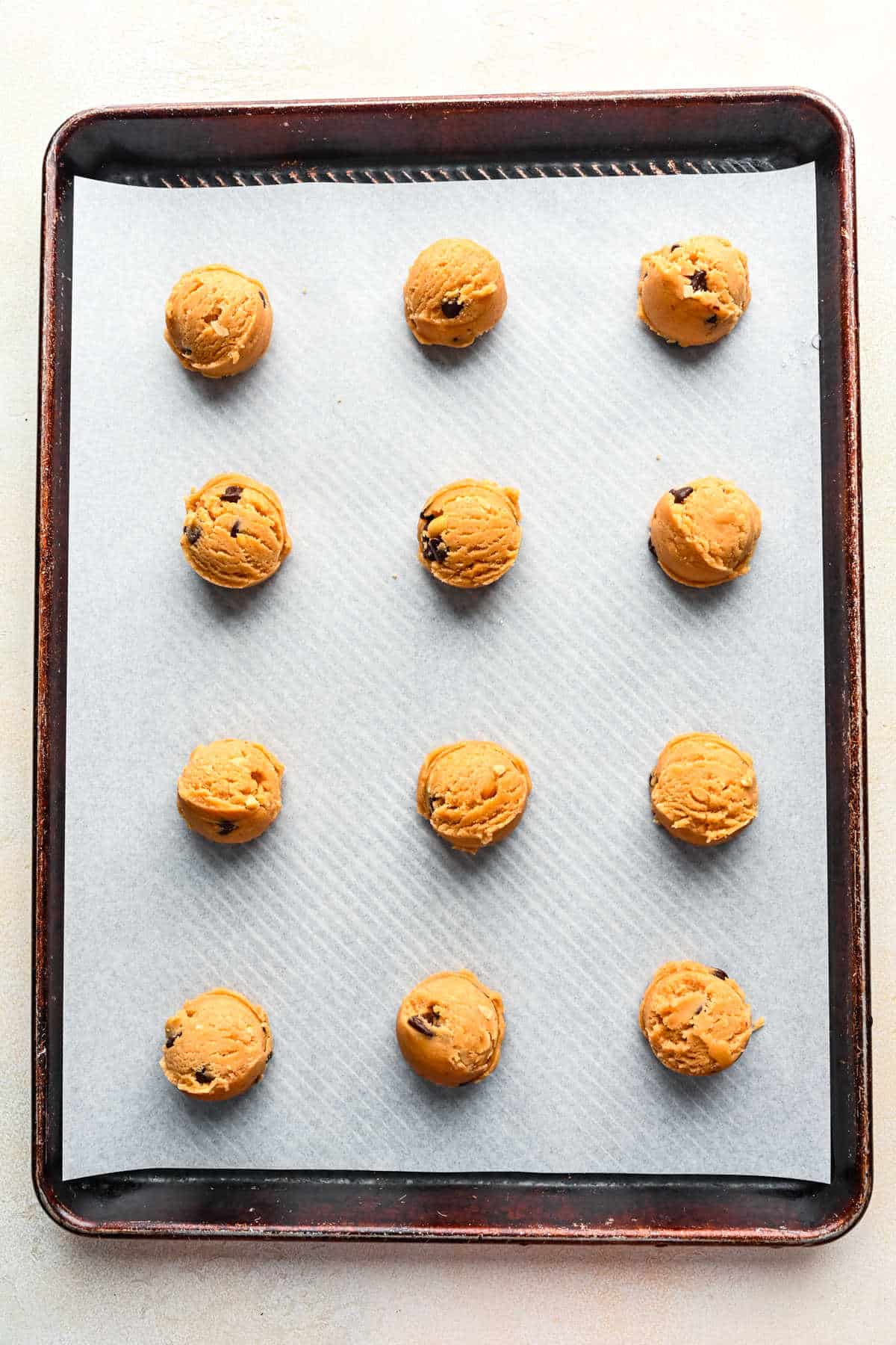 Peanut butter chocolate chip cookie dough on a baking sheet.