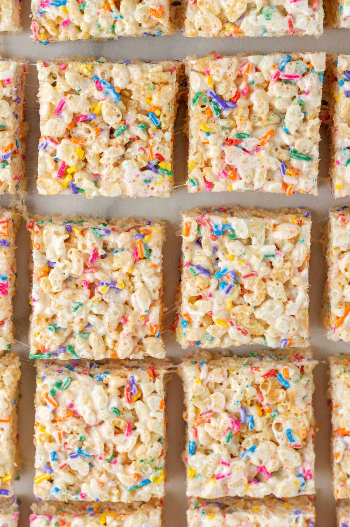 Cut squares of funfetti rice krispies in rows.