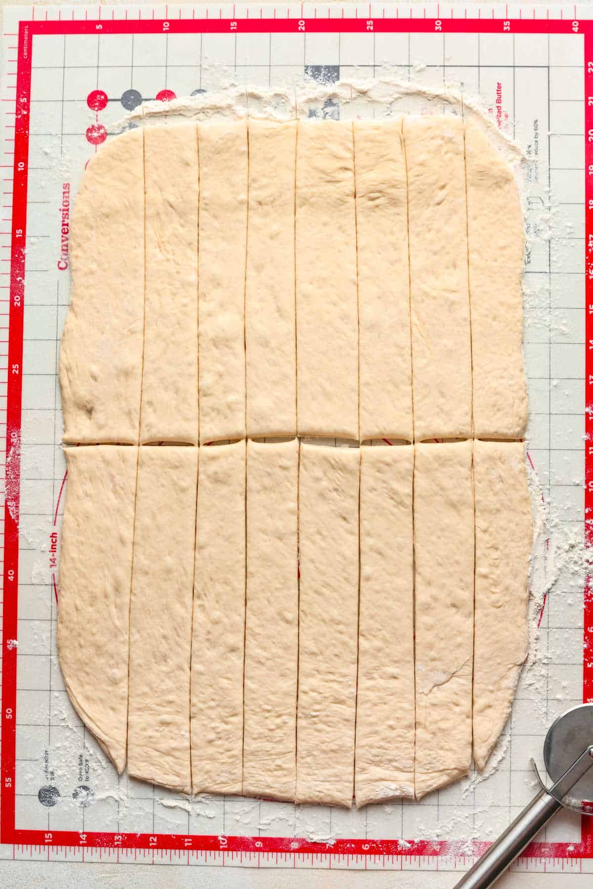 Rolled out breadstick dough cut into strips.