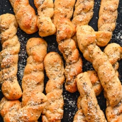 Homemade breadsticks on a piece of dark slate.