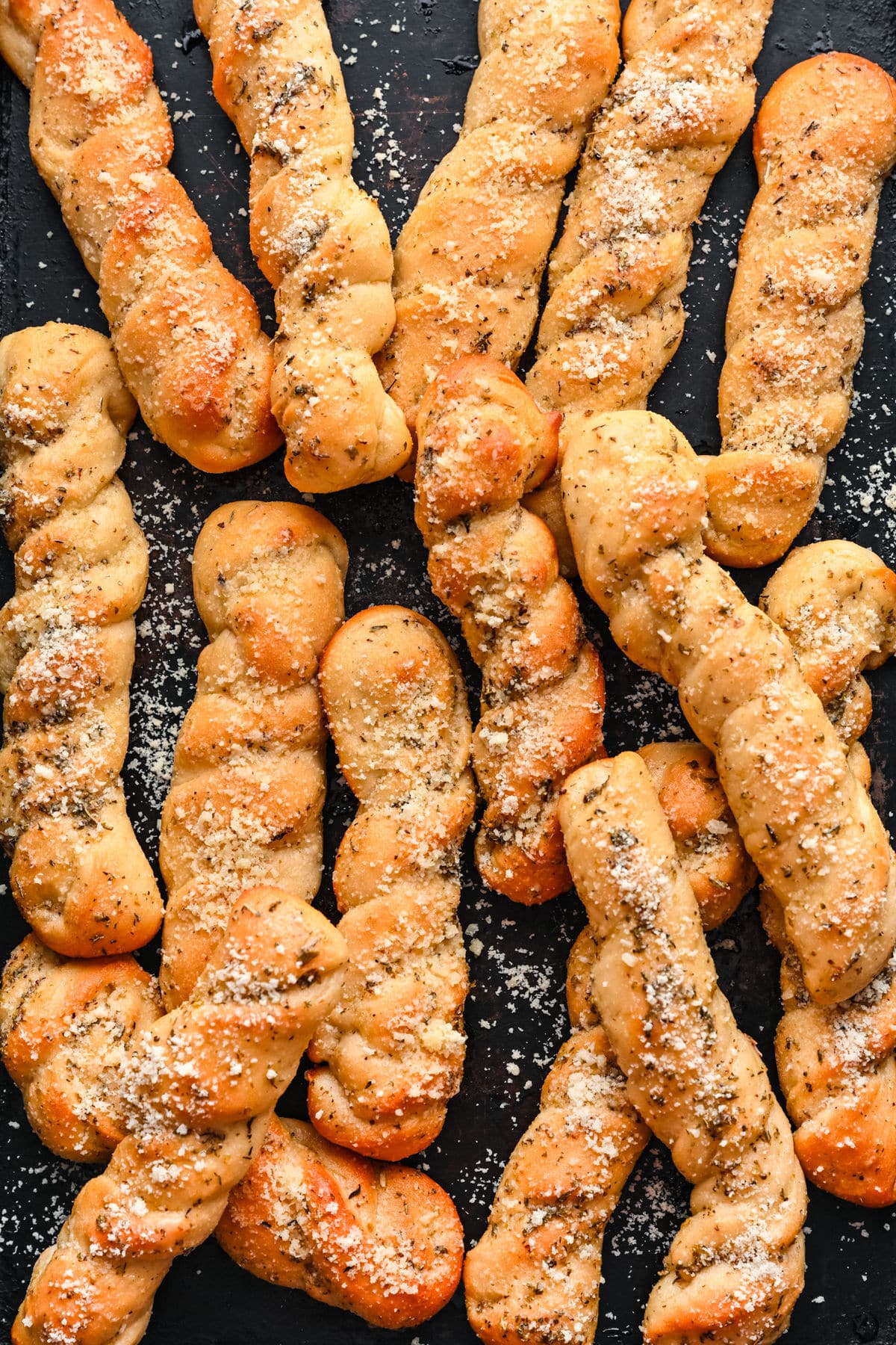 Easy Homemade Breadsticks Homemade breadsticks on a piece of dark slate.