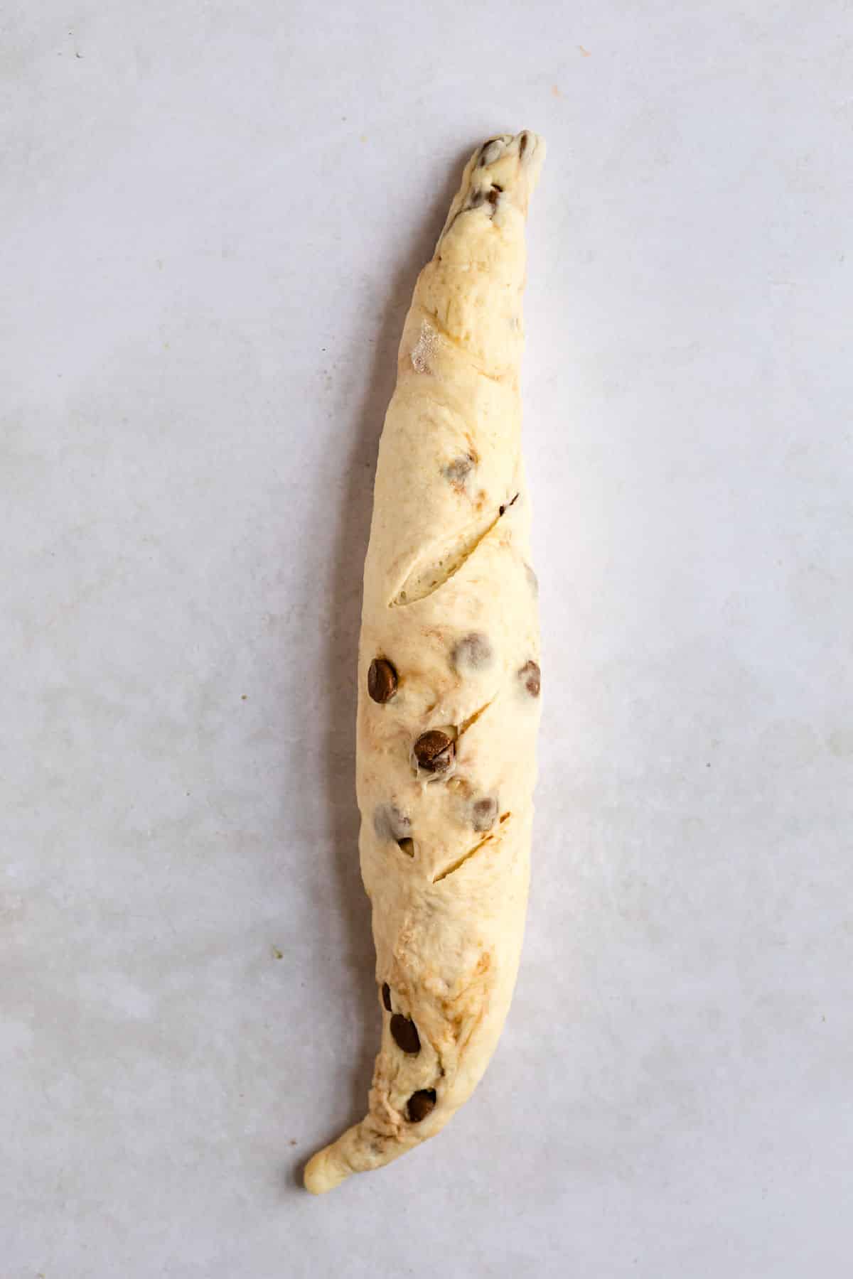 Chocolate chip baguette dough with slashed on top. 
