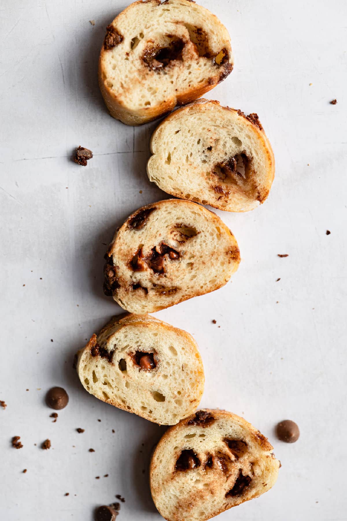 Slices of a chocolate chip baguette in a vertical line.