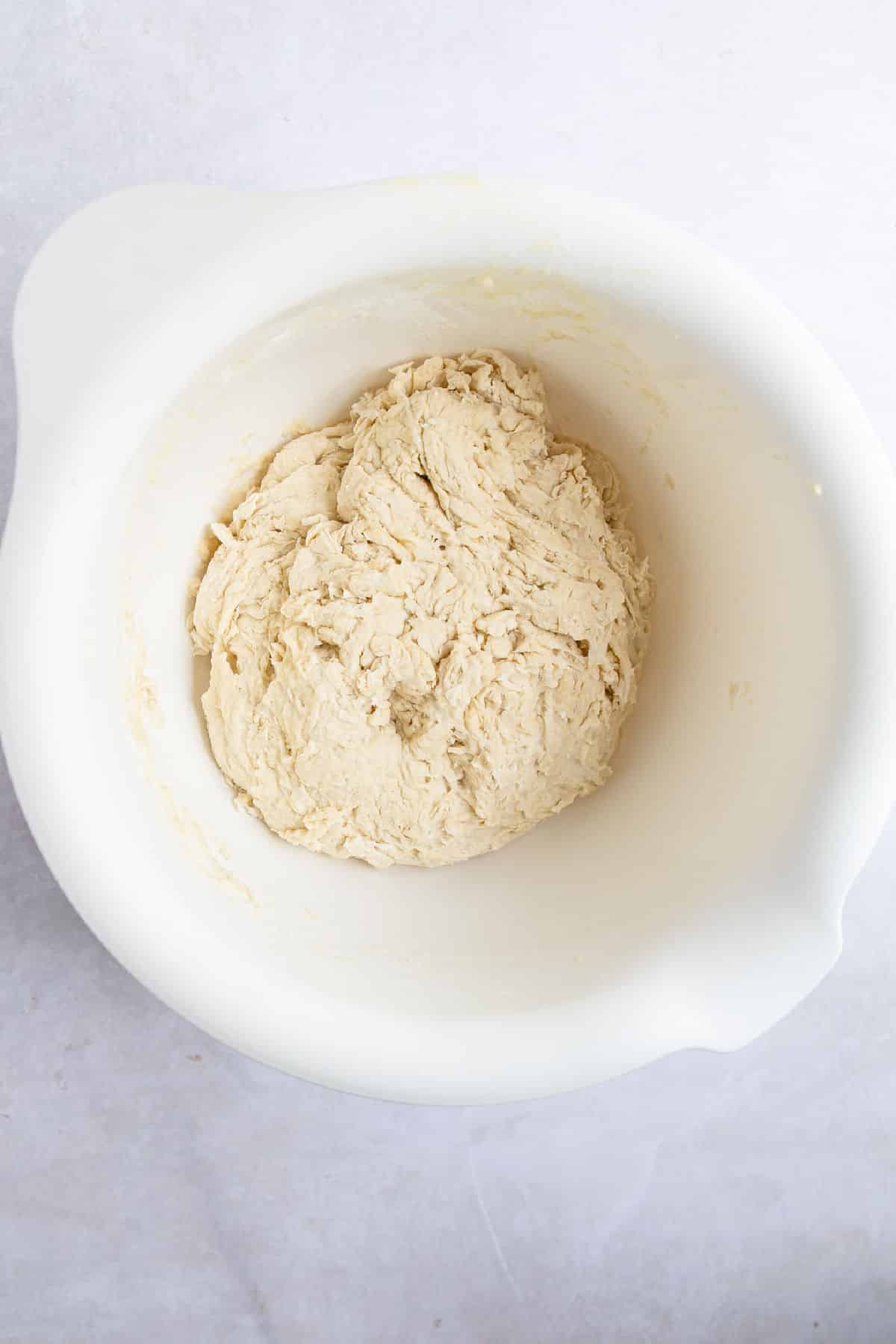 Chocolate chip baguette dough in a white mixing bowl. 