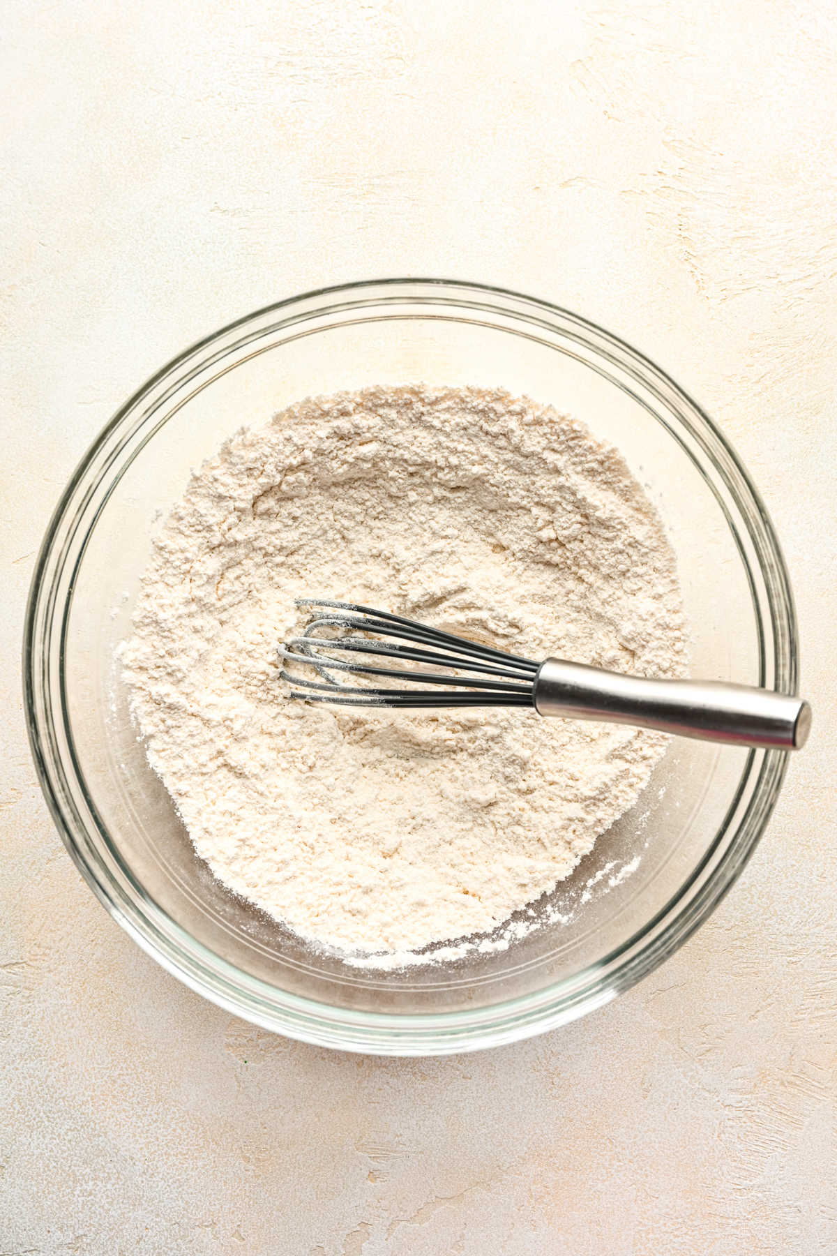 Flour and salt whisked together in a glass mixing bowl. 