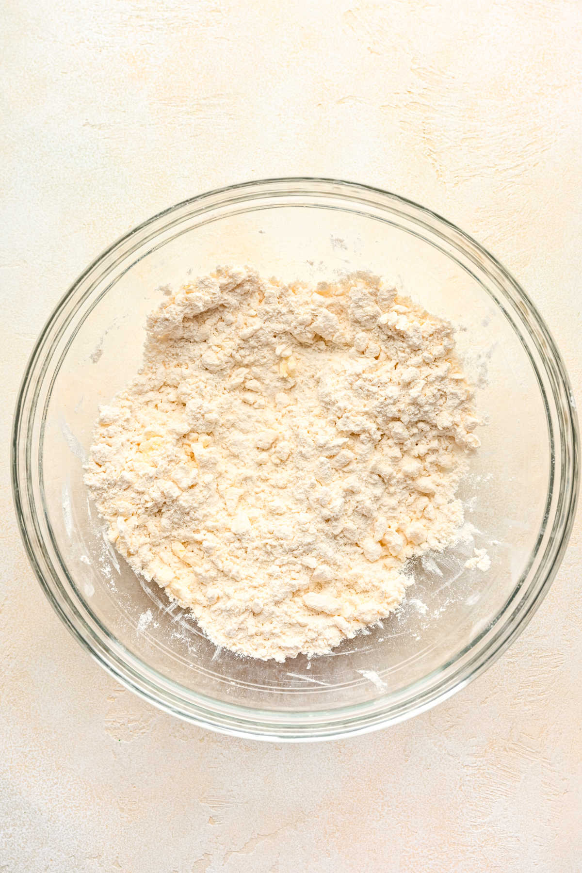 Cold butter cut into flour mixture in a glass mixing bowl. 