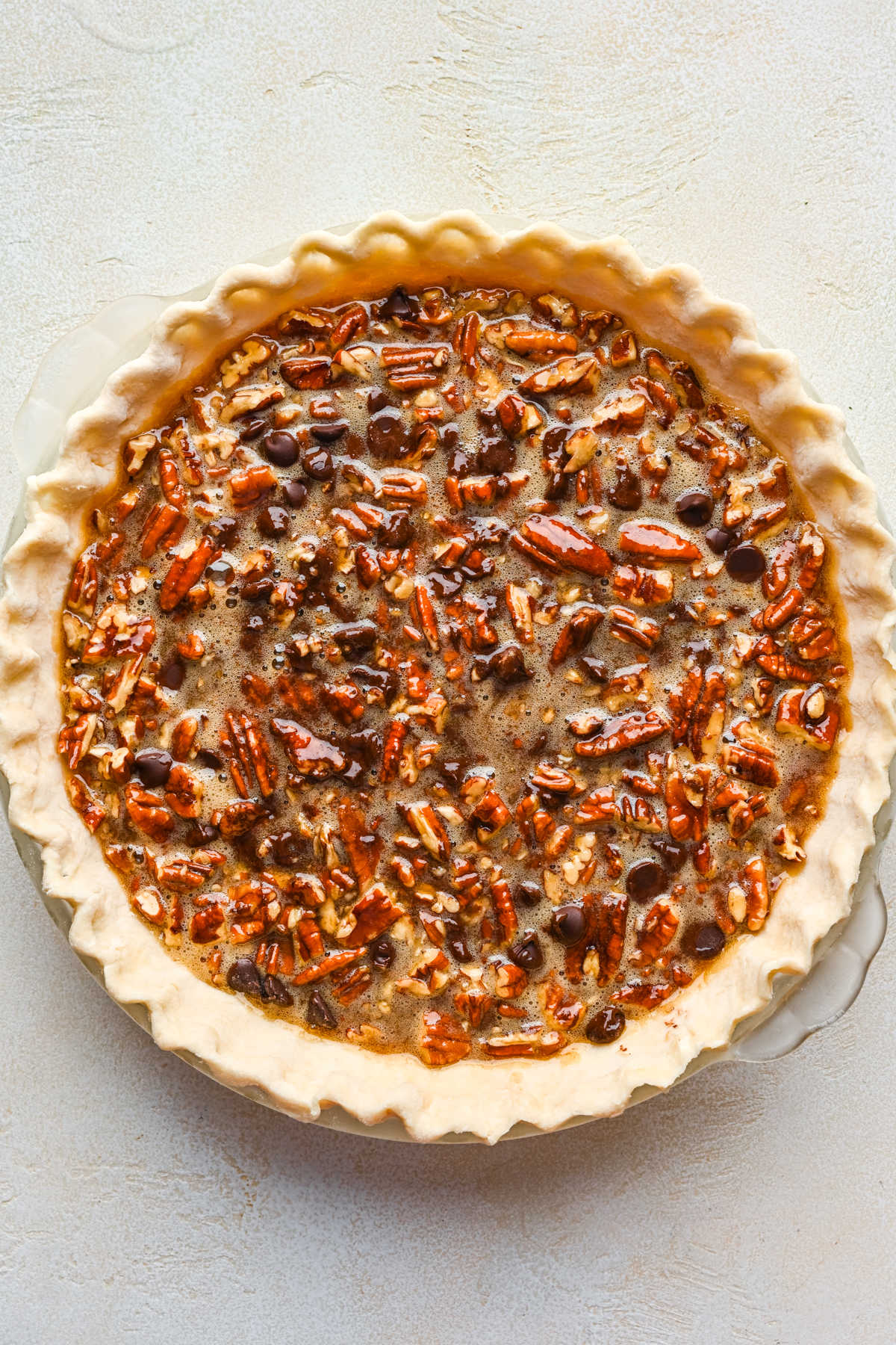 Chocolate pecan pie filling in an unbaked pie crust. 