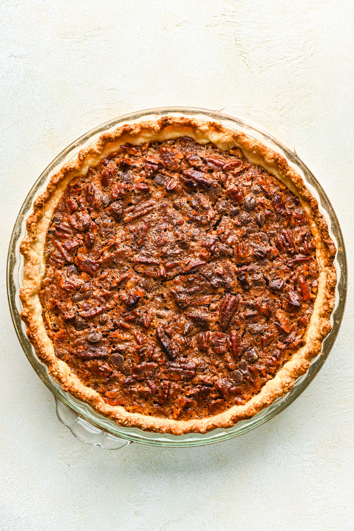 Baked chocolate pecan pie in a glass pie pan.