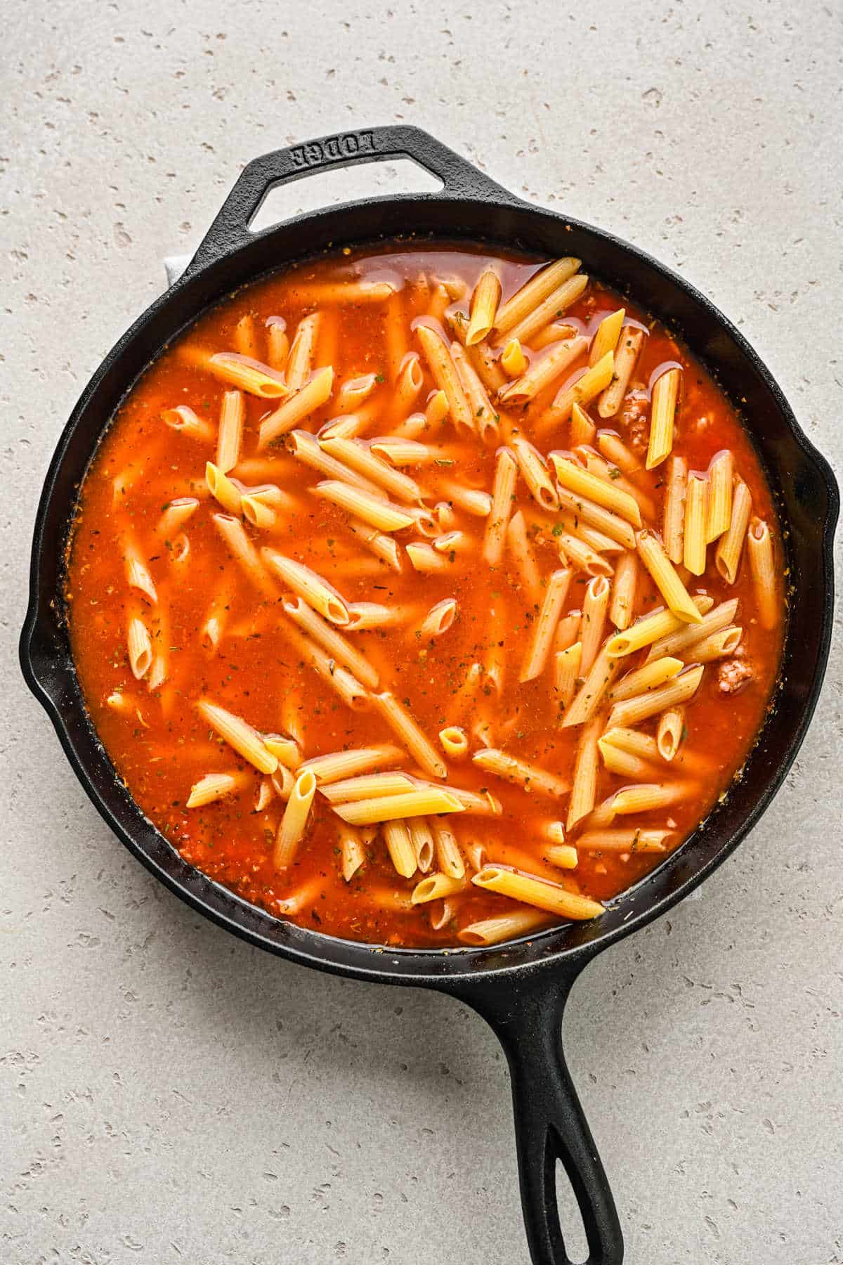 Water and noodles in tomato Italian sausage sauce. 